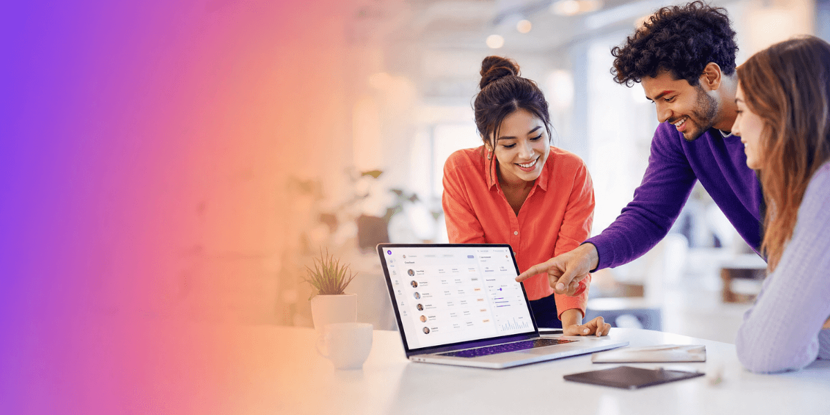 Três jovens profissionais sorriem e analisam dados em um notebook em um escritório moderno. A imagem possui um fundo desfocado e um efeito de degradê roxo e laranja no lado esquerdo.